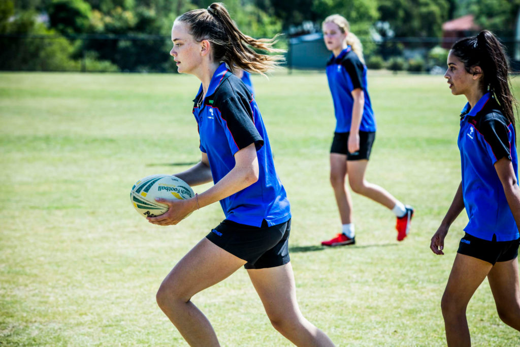 Three Luther College girls play touch rugby