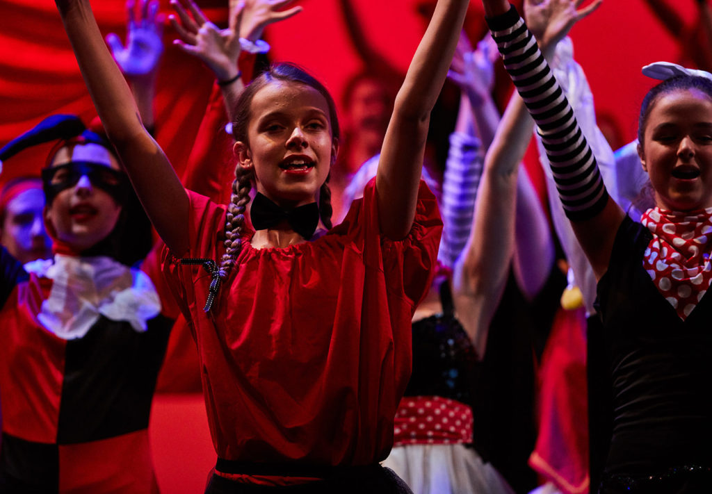 A group of Luther College theatre students hold their hands up while performing